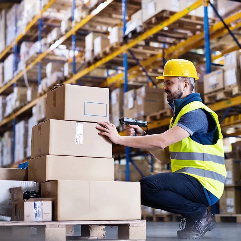 A worker scanning boxes in a warehouse.