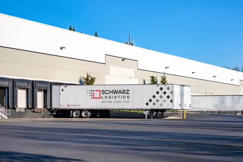 A dry van trailer, prominently labeled with the "SCHWARZ LOGISTICS" logo and the slogan "ON TIME. EVERY TIME."