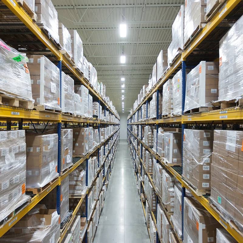 High shelves stocked with pharmaceutical products in a warehouse.