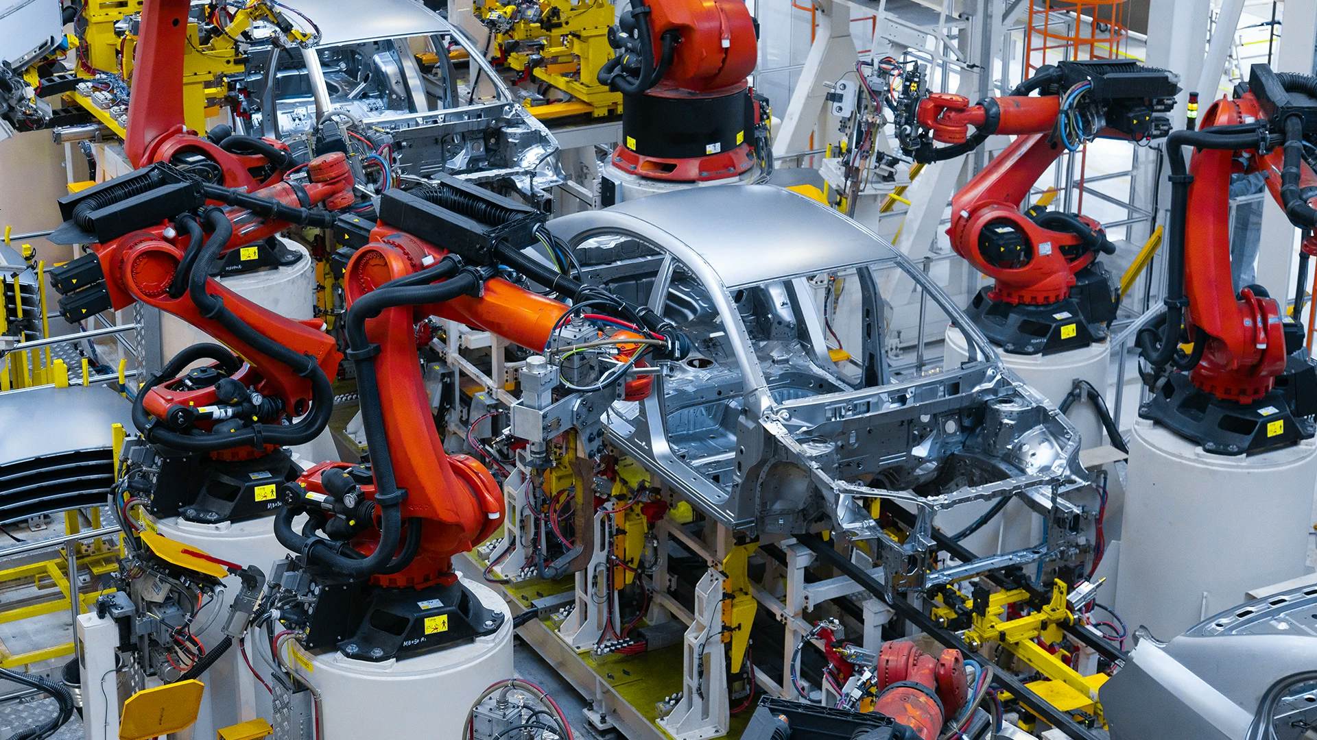 Robotics assembling car in automotive factory.