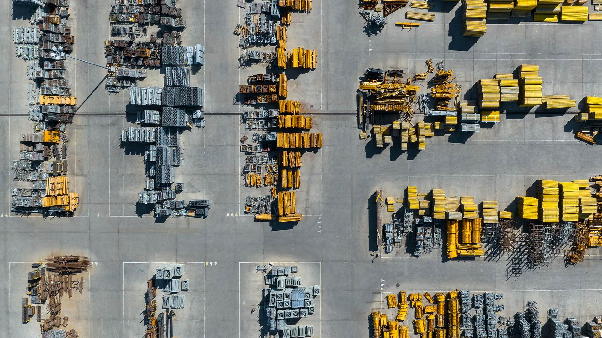 Aerial view of a construction yard with organized arrays of materials and machinery.
