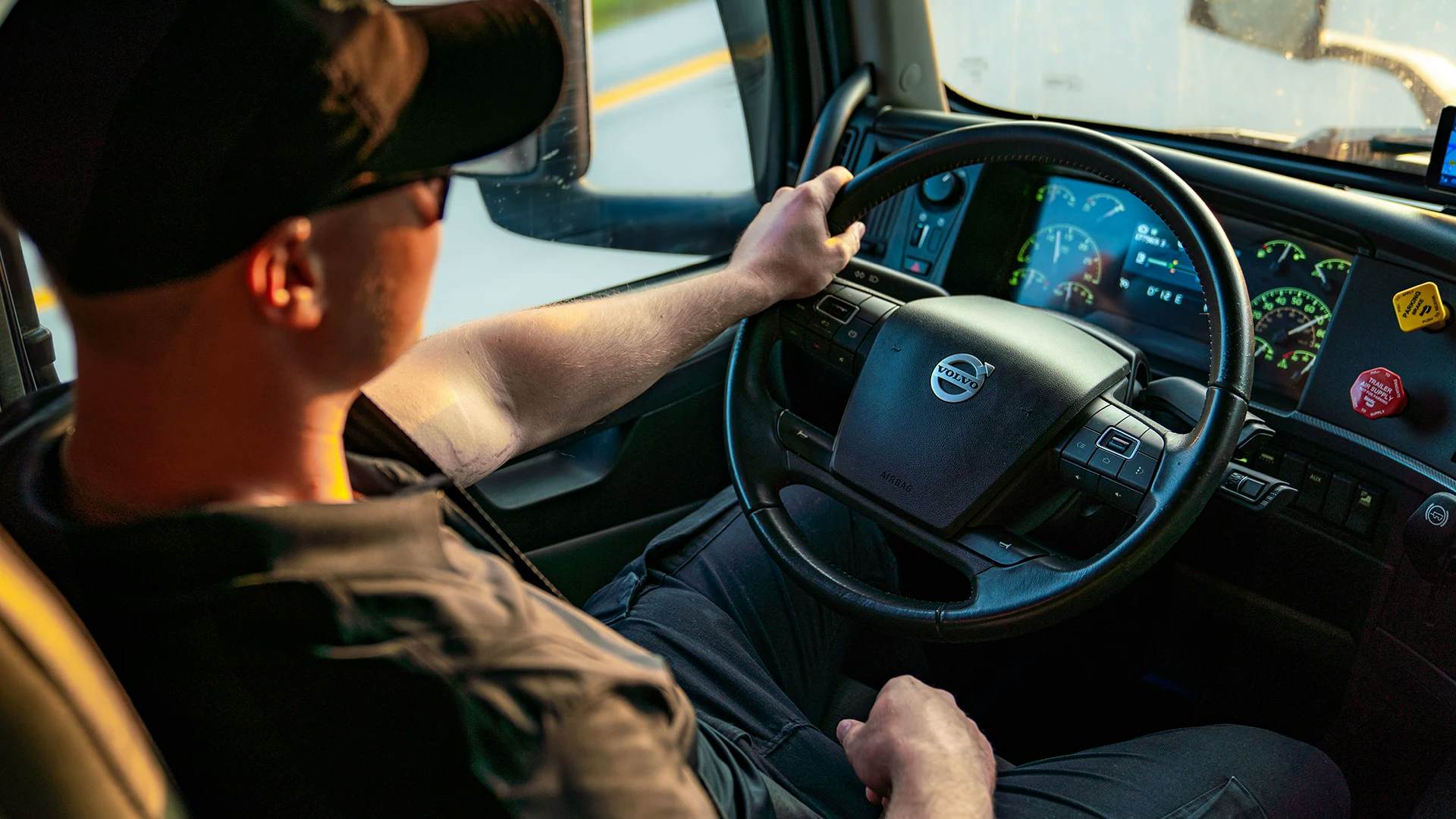 Interior of a Volvo truck with a clear view of the steering wheel and dashboard, highlighting the driver's seat and environment.