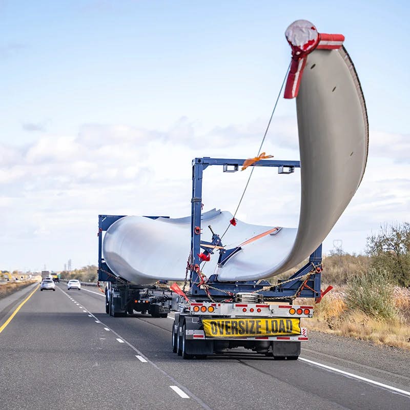 Truck on the road transporting a wind mill blade.